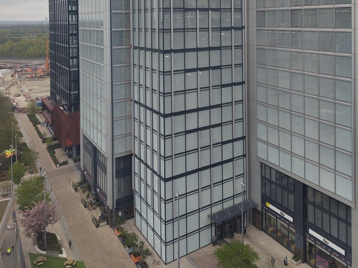 Glass office towers at Endeavour Square in Stratford, east London, with a covered entrance at street level